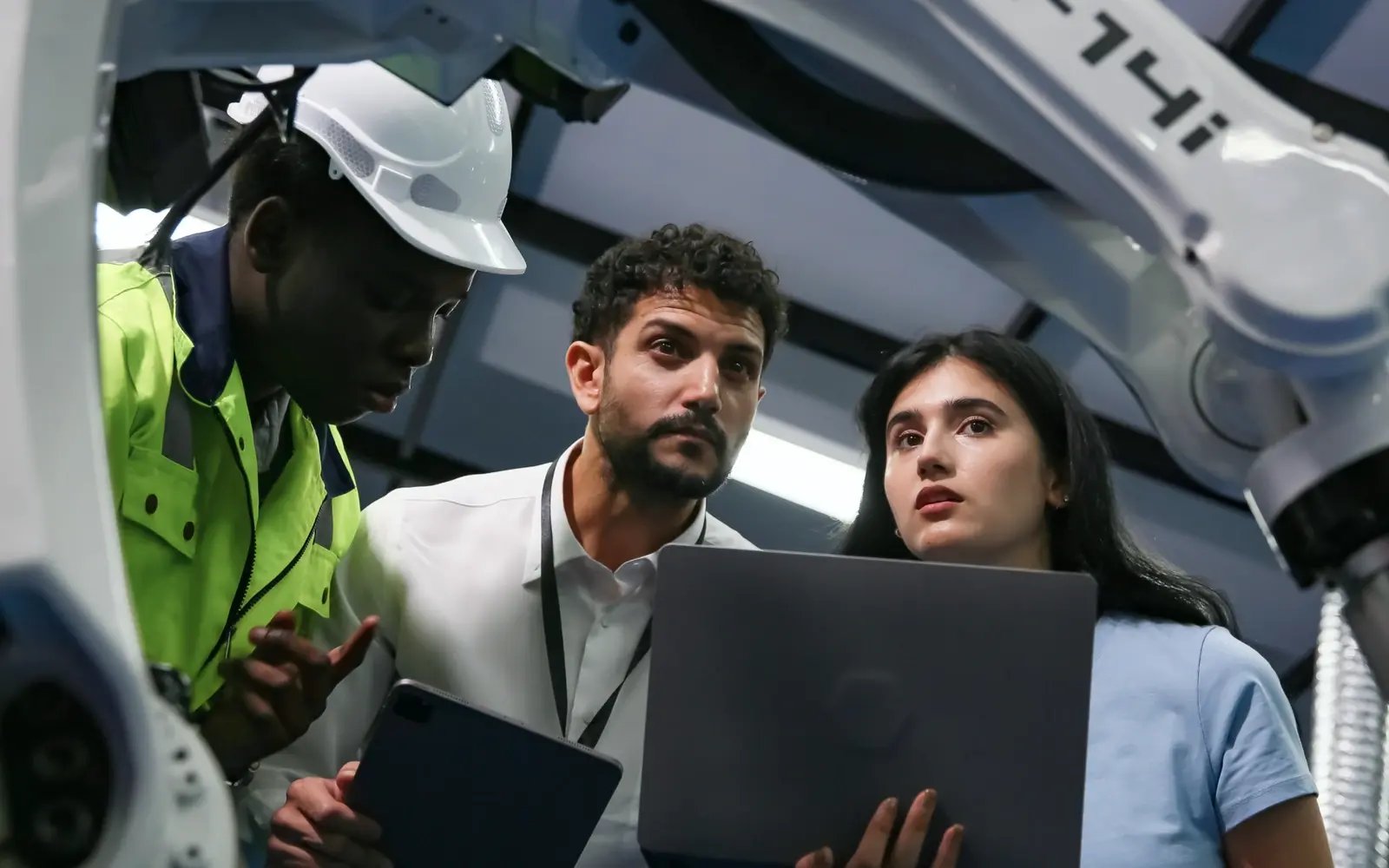 Engineers inspect industrial energy equipment while reviewing readings on a tablet