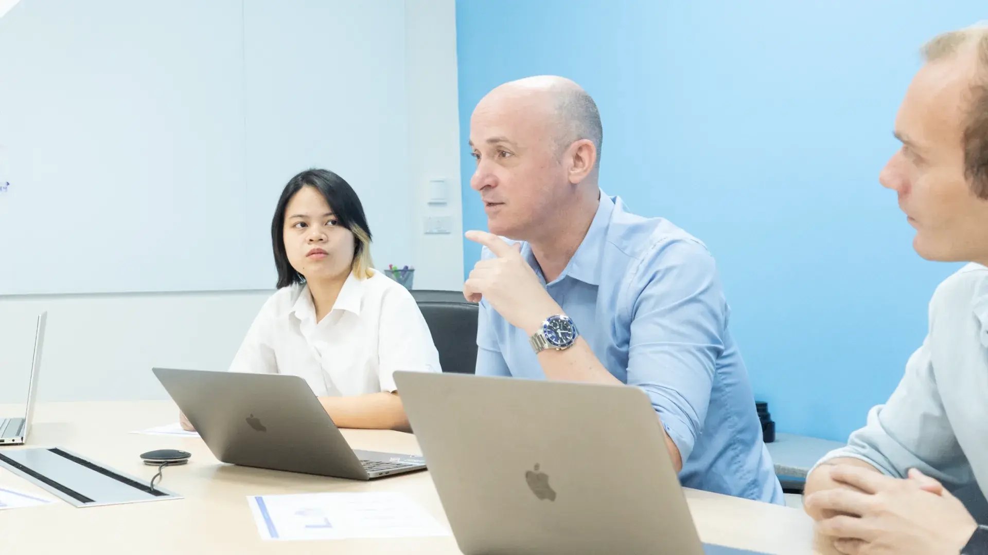 Three Seven Peaks colleagues discussing data strategy around a meeting table with laptops.