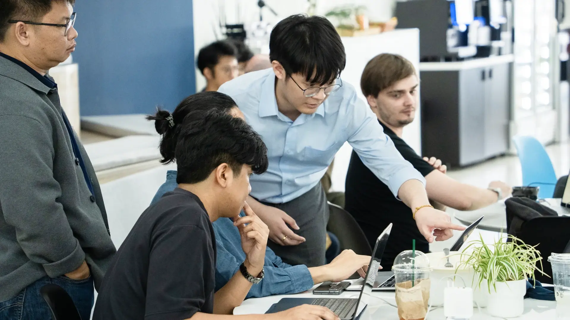Karn collaborates with colleagues around laptops in the Seven Peaks office.